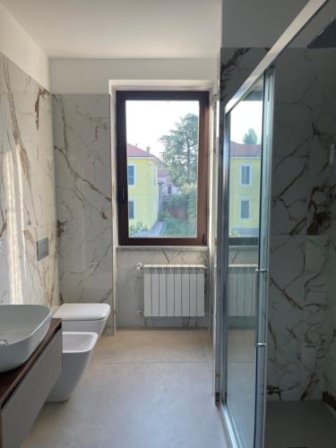 baño con lavabo y aseo y ventana en GC Petit Palais, en Gallarate