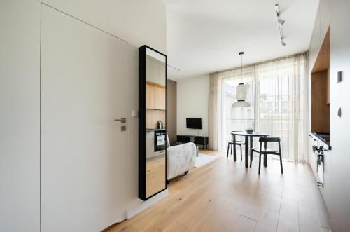 a living room with a table and a bedroom at Centrum Nauki Kopernika Luxury Studio in Warsaw