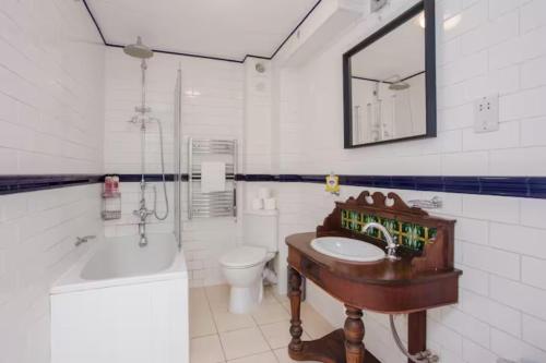 a bathroom with a sink and a tub and a toilet at Modern & Spacious 2BD Apartment in Limehouse in London