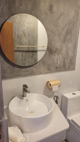 a bathroom with a white sink and a mirror at The Sunset Villa in Dhiffushi