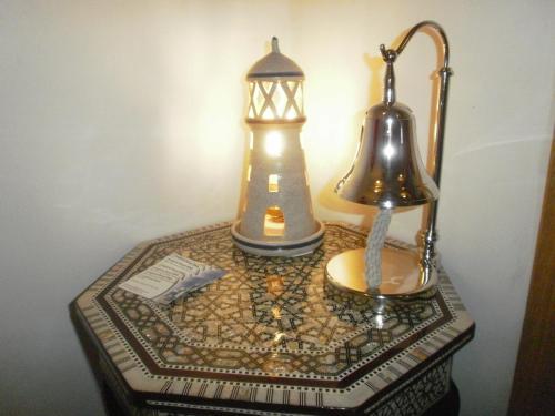 a table with a lantern and a lamp on it at Langland Road B&B in The Mumbles