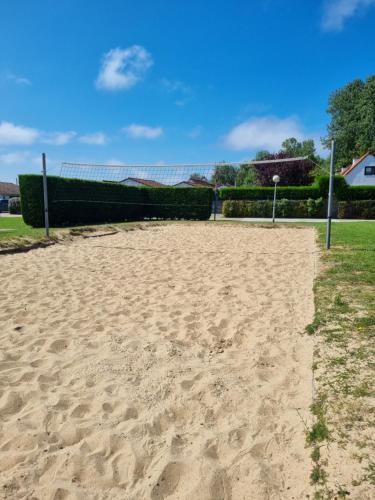 a sandy volleyball court with a net in a field at vakantiewoning 266 in De Panne