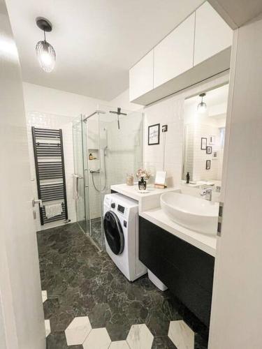 ein Badezimmer mit einer Waschmaschine und einem Waschbecken in der Unterkunft Apartment *MALA* in Žalec