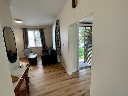 a living room with a black couch and a mirror at Lord Medford Apartments in Medford