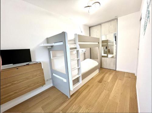 a bedroom with bunk beds and a television in it at 3 Pièces, Standing, Centre, 2 Sdb, 2 WC, Balcon in Deauville