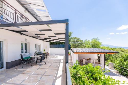 an outdoor patio with a pergola and a table and chairs at Apartmani Katica in Povile