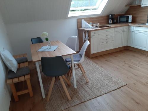 a kitchen with a wooden table and chairs in a room at Ferienwohnung Marion in Wallenborn