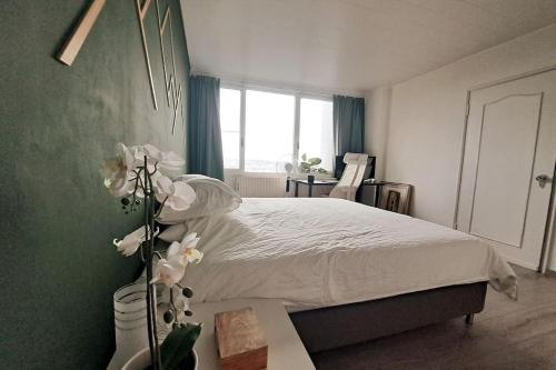 a bedroom with a bed with white sheets and a window at Airport Access Apartment - Your Gateway to Comfort in Charleroi
