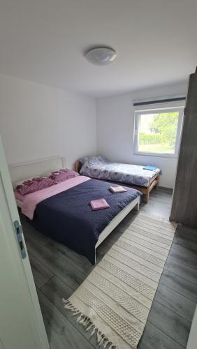 1 dormitorio con 2 camas y ventana en Vila MM Boračko jezero, en Konjic