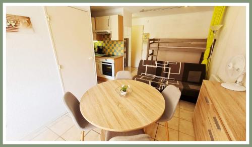 eine Küche mit einem Holztisch und Stühlen im Zimmer in der Unterkunft Bel Appartement cap dagde in Cap d'Agde