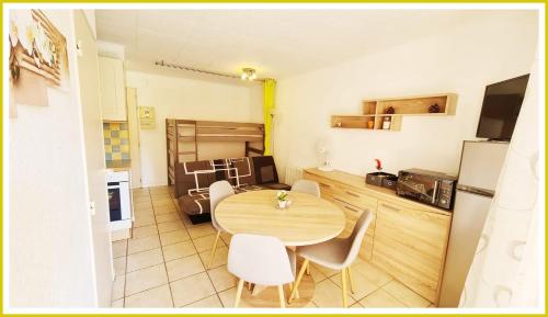 eine Küche und einen Tisch und Stühle in einem Zimmer in der Unterkunft Bel Appartement cap dagde in Cap d'Agde