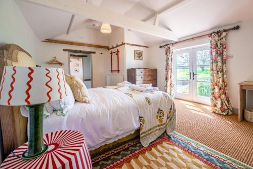 Un dormitorio con una cama grande y una ventana en Keepers Cottage by Big Skies Cottages en Itteringham