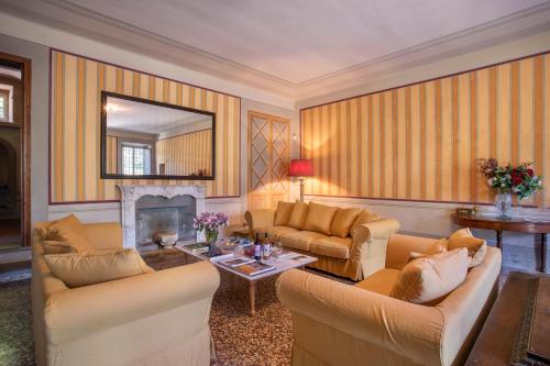 a living room with two couches and a fireplace at Villa Trenta Prestigious Villa Enchanting Garden in Lucca