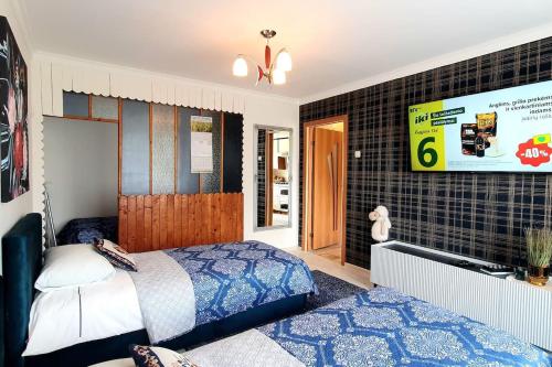 a bedroom with a bed and a tv on a wall at Studio apartment in Joniškis in Joniškis