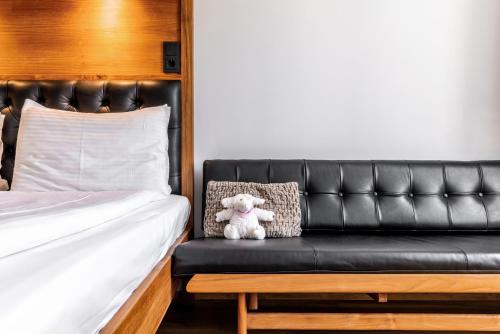 a teddy bear sitting on a bench in a bedroom at Hotel Von in Reykjavík