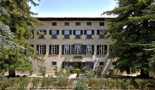 a large building with trees in front of it at Villa Trenta Prestigious Villa Enchanting Garden in Lucca