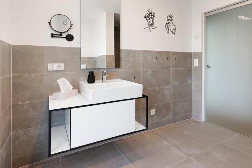 a bathroom with a white sink and a mirror at Seesehnsucht Höri in Gaienhofen