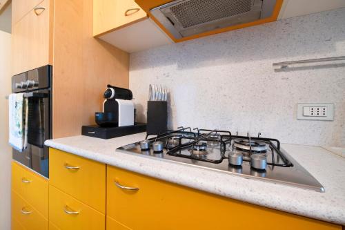 a stove top in a kitchen with yellow cabinets at Casa Marina Bellagio private garden in Bellagio