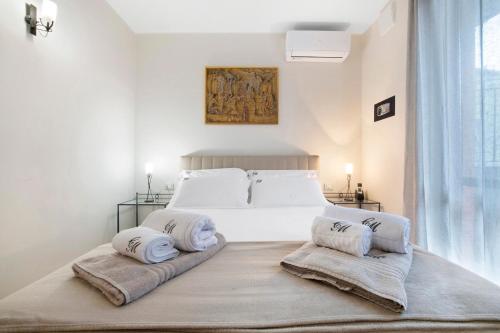 een witte slaapkamer met een groot bed met 2 kussens bij Casa Marina Bellagio private garden in Bellagio
