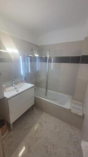 une salle de bain blanche avec une baignoire et un lavabo dans l'établissement Magnifique appartement Bas Gairaut aperçu mer, à Nice