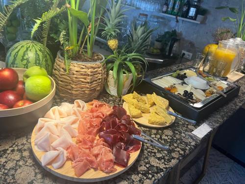 einen Tisch mit Teller mit Lebensmitteln auf einer Theke in der Unterkunft Balear Hotel in Ciutadella