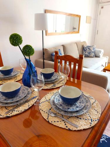 een eettafel met kommen en wijnglazen erop bij Apartment with sea view, La Mata in Torrevieja