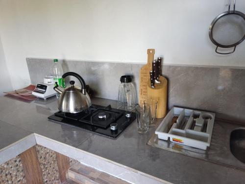 una encimera de cocina con fogones y tetera en Hakunarcoco mini suite, en Puembo