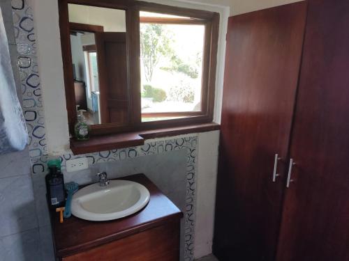 baño con lavabo y ventana en Hakunarcoco mini suite, en Puembo