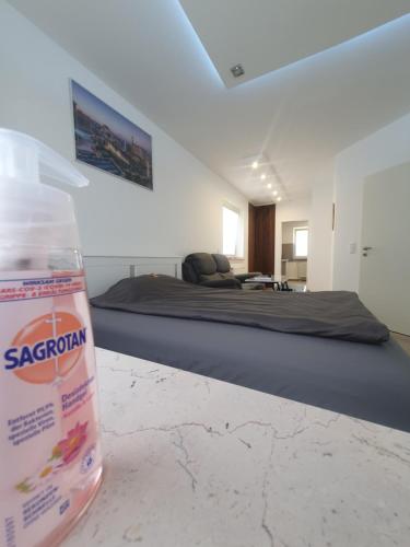 a bottle of water sitting on a table next to a bed at Las Vegas Apartment in Paderborn
