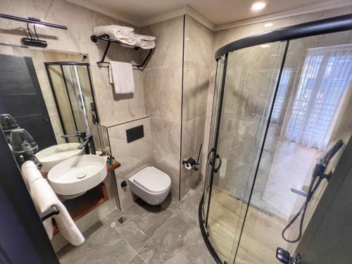 a bathroom with a shower and a toilet and a sink at Oji Hotel in Alanya