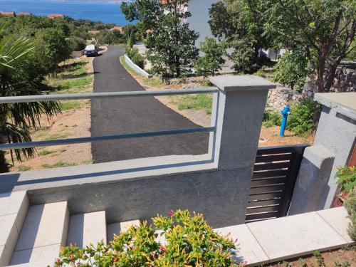 a stairway leading down to a road with a fence at Apartmani Katica in Povile