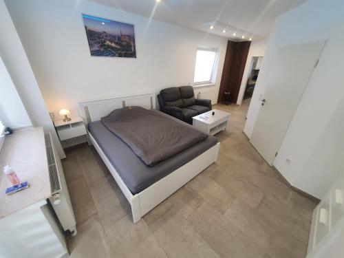 um pequeno quarto com uma cama e uma cadeira em Las Vegas Apartment em Paderborn