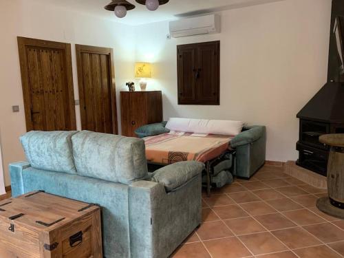 ein Wohnzimmer mit Sofa und Tisch in der Unterkunft Cortijo Los Pinillos in Pinos Genil