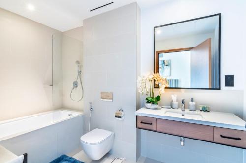 uma casa de banho com um lavatório, um WC e um espelho. em Welcome Home Apartments - VIDA Marina - Full Marina view - High Floor no Dubai