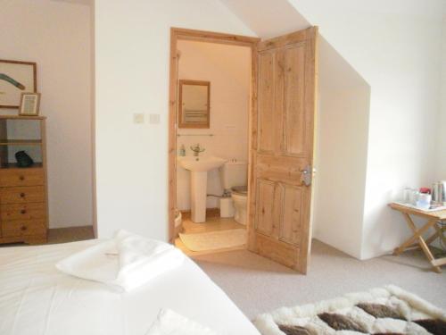 a bedroom with a door leading to a bathroom at Langland Road B&B in The Mumbles