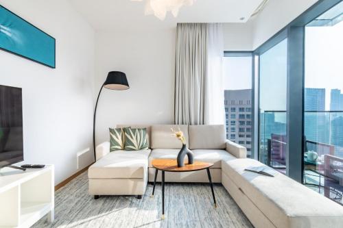 a living room with a couch and a table at Welcome Home Apartments - VIDA Marina - Full Marina view - High Floor in Dubai