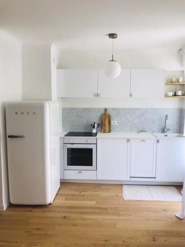 Il comprend une cuisine équipée d'appareils électroménagers blancs et d'un réfrigérateur blanc. dans l'établissement Magnifique appartement Bas Gairaut aperçu mer, à Nice