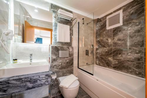 DIAMOND luxury Hotel في أنطاليا: حمام مع مرحاض ومغسلة ودش
