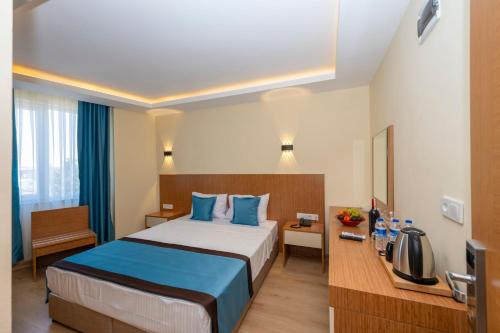 a hotel room with a large bed with blue pillows at DIAMOND Luxury Hotel in Antalya