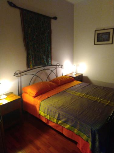 una camera con un letto e due luci su due tavoli di la casa di Aldo a Perugia