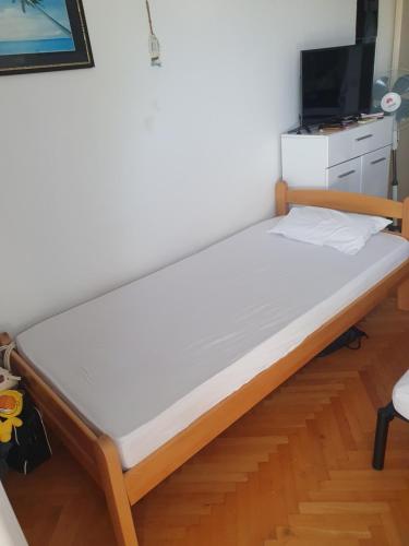 a large bed in a room with a tv at Apartman na najboljoj lokaciji , nedaleko od plaže in Bar