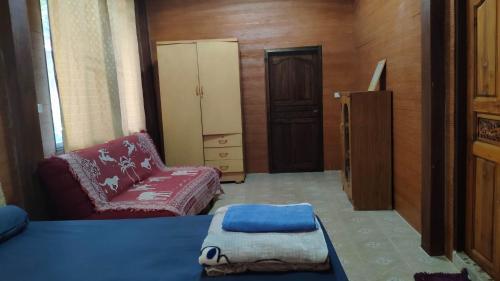 Habitación con cama, sofá y silla en บ้านพักพือวา Pue Wa Homestay, en Ban Yang