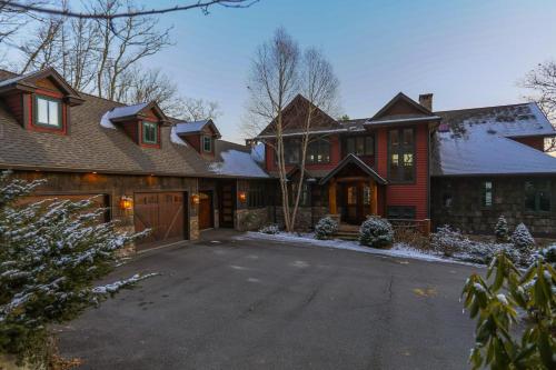 a large house with a driveway in the snow at Overlook Estate in The Farm in Banner Elk