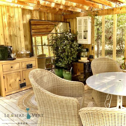 a patio with wicker chairs and a table in a kitchen at Le Chat Vert - Appartements Adults Only, propreté 10 sur 10 in Saint-André