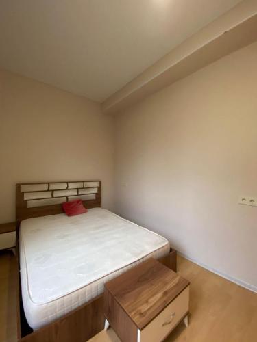 a small bedroom with a bed and a wooden table at Flats at Era Square in Batumi