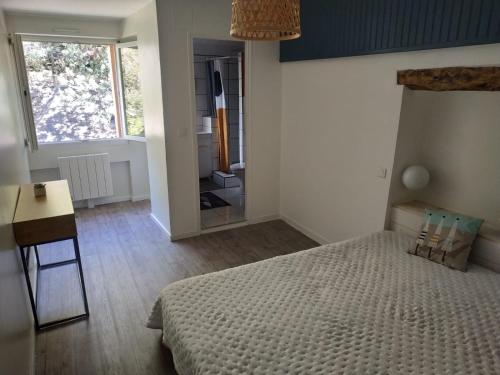 Schlafzimmer mit einem Bett, einem Schreibtisch und einem Spiegel in der Unterkunft Appartement, port de Binic in Binic