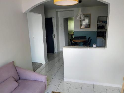 ein Wohnzimmer mit einem lila Sofa und einem Tisch in der Unterkunft Appartement, port de Binic in Binic