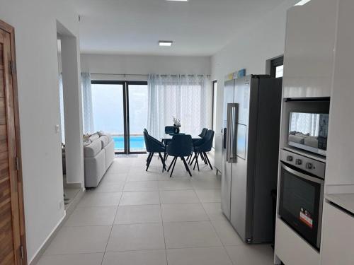 - une cuisine et une salle à manger avec une table et une vue dans l'établissement Azure 4 Bedrooms Haven Retreat: Where Tranquility Meets Turquoise Waters, Flic en Flac Mauritius, à Flic-en-Flac