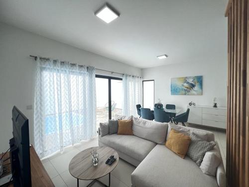 a living room with a couch and a table at Azure 4 Bedrooms Haven Retreat: Where Tranquility Meets Turquoise Waters, Flic en Flac Mauritius in Flic-en-Flac