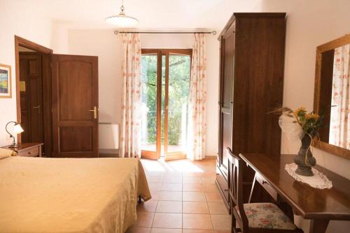 a bedroom with a bed and a table and a window at Agriturismo La Vecchia Fattoria in Orte